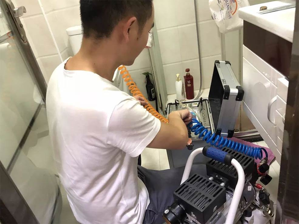 professional plumber using water pipe cleaning equipment